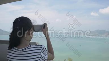 后景美女手持手机在观景塔拍照，海湾美景尽收眼底。